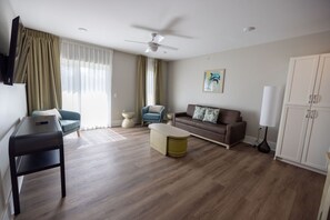 Una sala de estar moderna con un sofá, un sillón, una mesa de centro y un televisor.