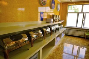 A buffet area with a long counter and multiple food dispensers.