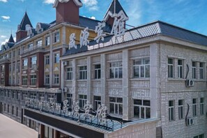 A multi-story building with a traditional architectural style, featuring a balcony with railings and a series of windows. - Shengyuan Hotel (Ergun)