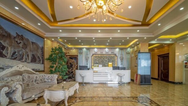 Un vestíbulo amplio con candelabro, una recepción, un sofá grande y una mesa de centro.