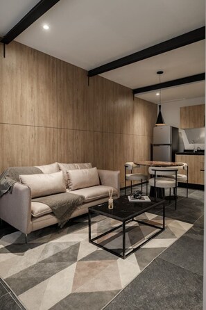 Relax in this stylish living space with a sofa, dining area, and fully equipped kitchen.