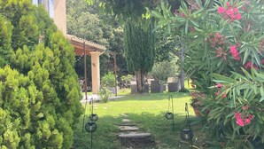 A garden pathway leading to a covered patio area with outdoor seating. - Charming house in Provence, quiet and pleasant (Aubignan)