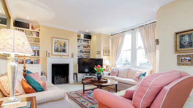 Una sala de estar con chimenea, televisor y sofá.