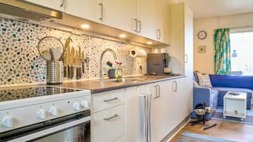 A modern kitchen with a built-in oven, a coffee machine, and a sink.