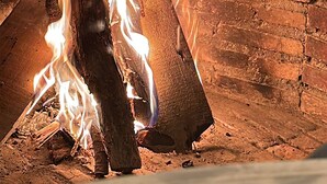 A fireplace with burning logs and flames. - CASA RURAL EL POZO (San Bartolomé de Corneja)