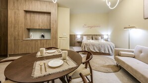 Une chambre d’hôtel moderne comprenant un coin repas, un lit et un espace salon.