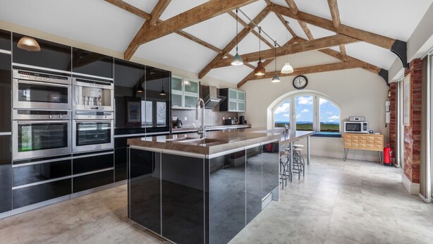 A modern kitchen with built-in appliances, a central island, and a view of the outdoors.