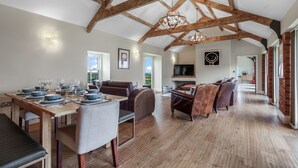 A spacious dining area with a wooden ceiling, a television, and a view of the outdoors.