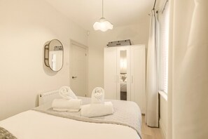 King-size bedroom with wardrobe, wall mirror and natural light from window