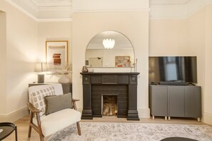 A living room with a fireplace, a television, a sofa, and a coffee table.