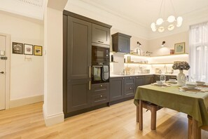 Modern kitchen and dining area with fitted cabinetry and table for four