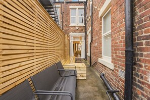 Private backyard seating area with wooden screening and outdoor chairs