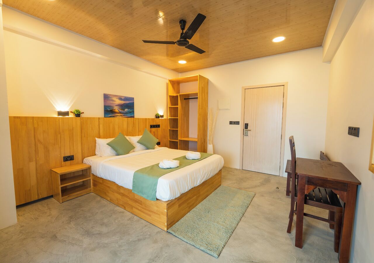 Un dormitorio con una cama de madera, una mesita de noche, un escritorio y una silla.