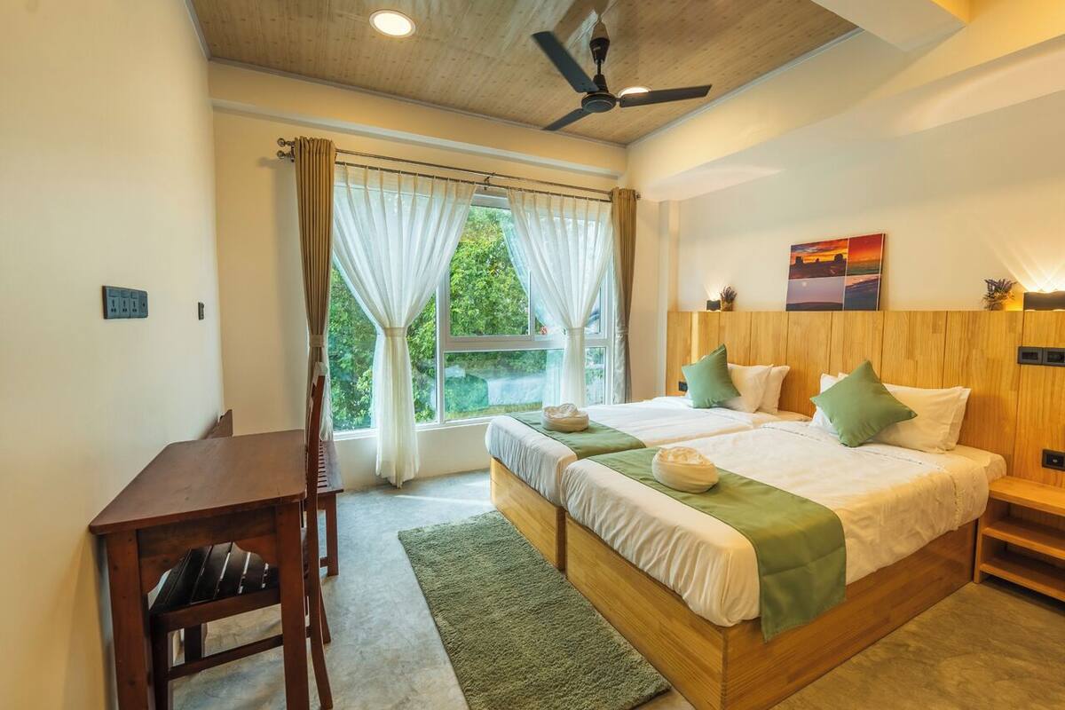 A bedroom with a wooden bed, a desk, and a chair.