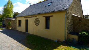 A yellow building with a stone exterior, a sloped roof, and a small window. - Country house in Brière, 20 minutes from the beach. (Donges)