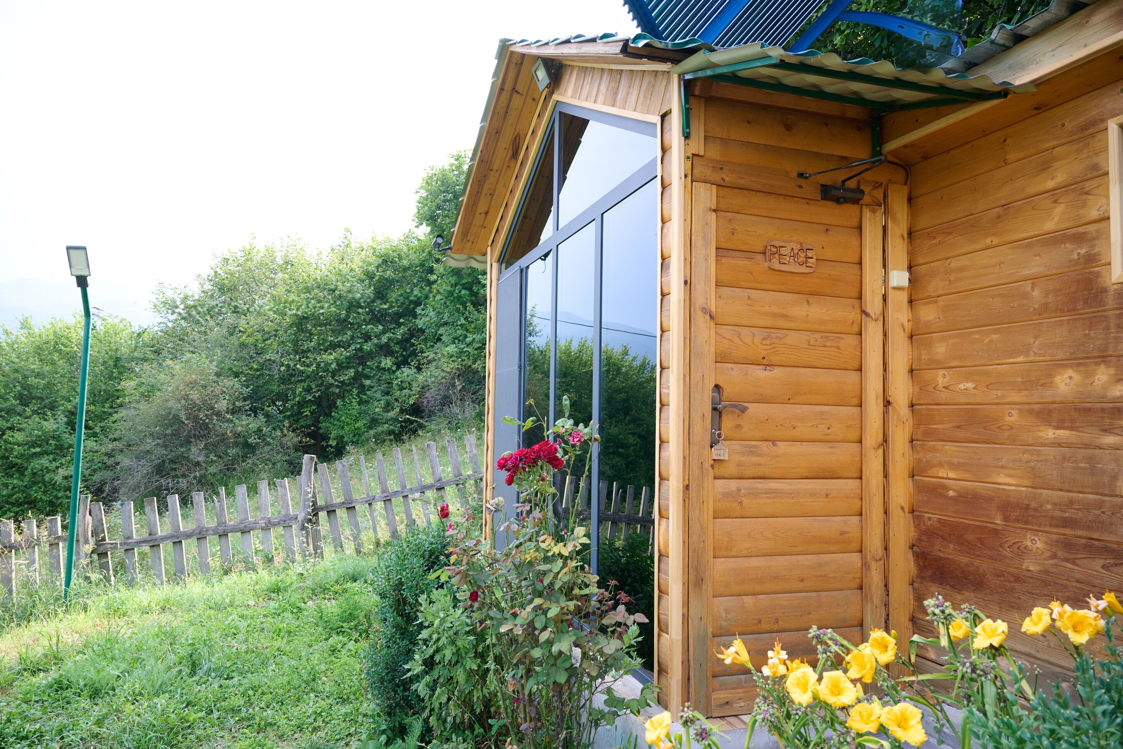 Una cabaña de madera con un ventanal grande y una puerta con la leyenda 'PEACE'.