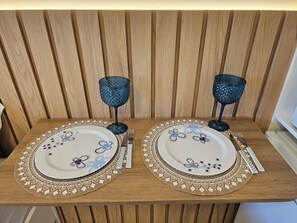 A beautifully set table with a floral patterned placemat and fine china, complemented by elegant candle holders.