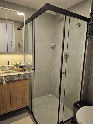 Enjoy a sleek, functional bathroom with a glass-enclosed shower, granite countertop, and sink.