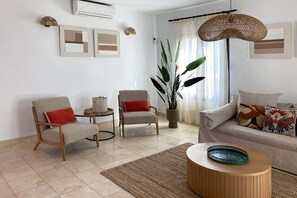 A living room with a sofa, two armchairs, a coffee table, a potted plant, and artwork on the walls. - Salobre Morro Golf 9 (Maspalomas)