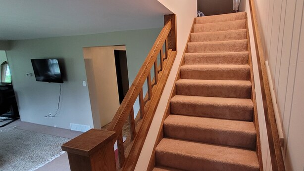 A carpeted staircase with wooden railings leading to an upper floor. - The Homestead - modern beauty, spacious, private, super clean! (Chassell)