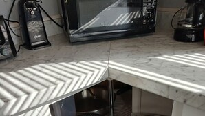 Une cuisine équipée d’un four à micro-ondes, d’un grille-pain et d’une machine à café, le tout posé sur le plan de travail.