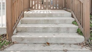 A wooden staircase leading to a building entrance with a covered porch. - Vacation stay walkable to Vanderbilt, bars and dining (Nashville)