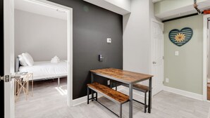 Un dormitorio con una cama, una mesita y un banco.