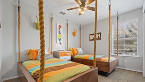 A bedroom with two beds, each with a rope canopy, a ceiling fan, and a window with blinds. - Spacious 5BR / Perfect for Families & Groups (Universal City)
