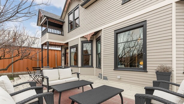 A two-story house with a patio area featuring outdoor furniture and a wooden fence. - Spacious main level 2 bdrm off Missoula Hip Strip, across river from downtown (Missoula)