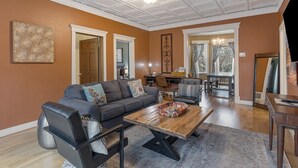 A spacious living room with a dark grey sofa, a wooden coffee table, and a black leather chair. - Spacious main level 2 bdrm off Missoula Hip Strip, across river from downtown (Missoula)