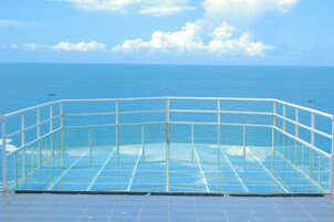Varanda envidraçada com vista para o mar.