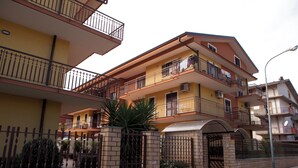 A multi-story residential building with balconies, a gated entrance, and a brick facade. - B&B Casa Mauro (Linguaglossa)