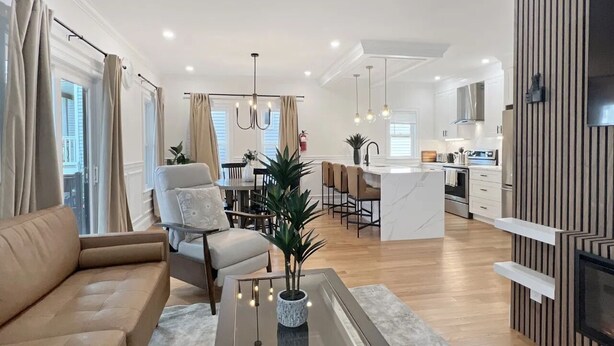 Una sala de estar moderna con un sofá, una mesa de centro con una planta, y un comedor con sillas y una mesa.