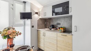A modern kitchen with a Bosch microwave, a sink, and a dining area with a vase of flowers and wine glasses.