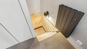 A modern staircase with a textured wall and a dark radiator.