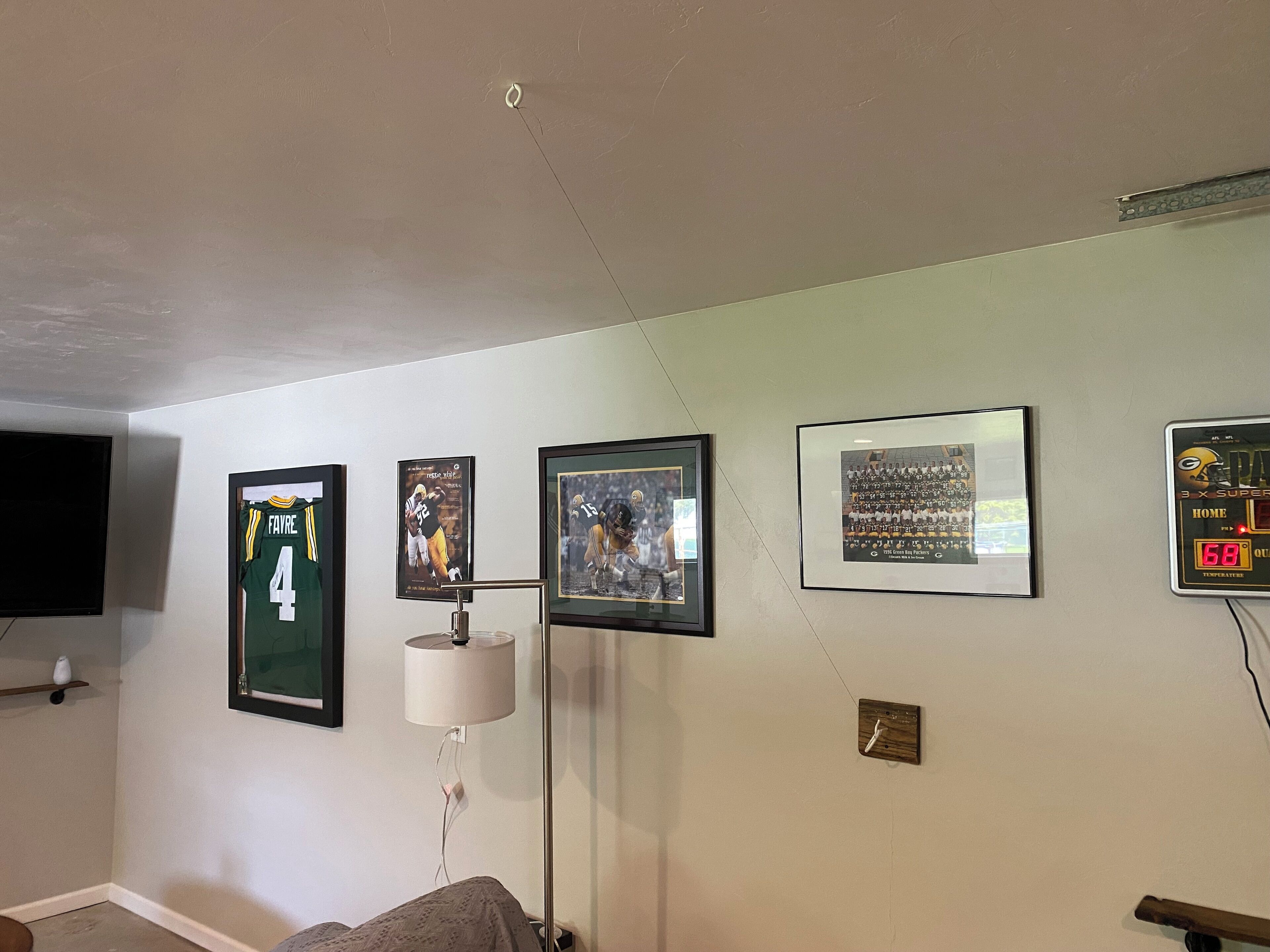 Una stanza con un letto, una lampada, una TV e memorabilia sportive incorniciate alle pareti.