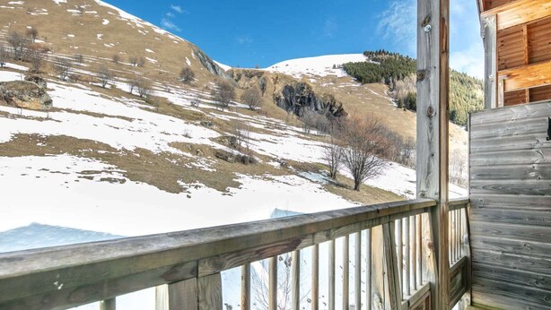 A wooden cabin with a deck overlooking a snow-covered landscape and distant mountains. - Apartment in Saint-Sorlin near Ski Resort (Saint-Sorlin-d´Arves)