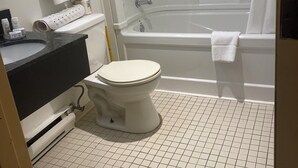 A bathroom with a toilet, sink, and bathtub. - Sunset Inn Kenora (Kenora)