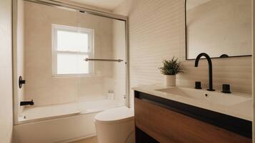 A modern bathroom with a bathtub, toilet, and sink.
