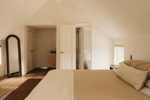 A bedroom with a large bed, a wooden floor, a wardrobe, and a mirror. - Great Lodge at Carter Bridge Estate (East Durham)