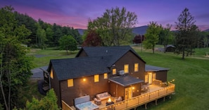 Una amplia casa de madera con jacuzzi, terraza y zona de estar al aire libre.