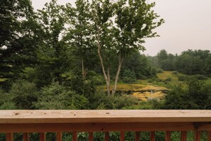 A wooden deck overlooking a natural landscape with trees and a pond. - Great Lodge at Carter Bridge Estate (East Durham)