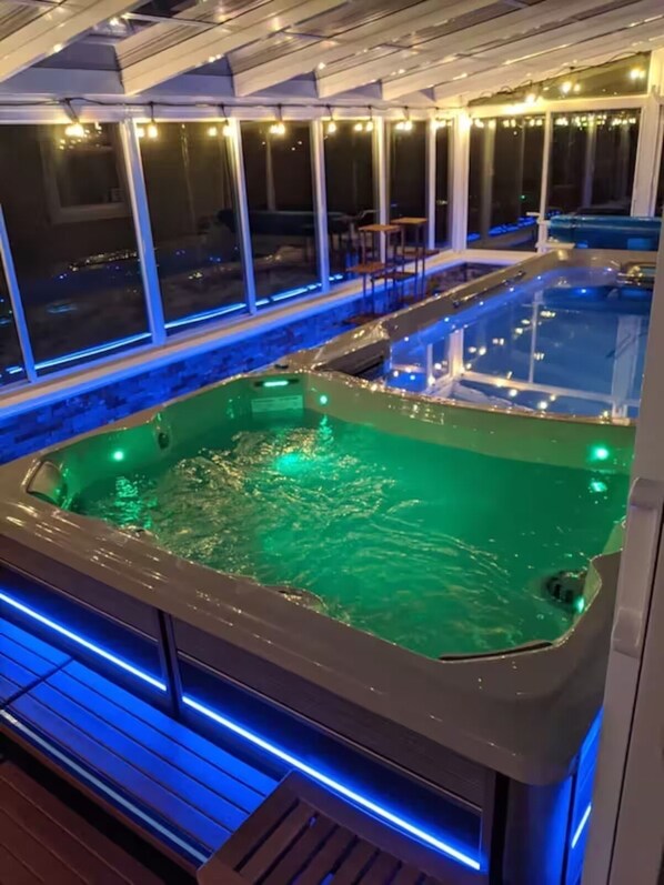 Un espace avec un bain à remous offrant une vue sur la ville la nuit.