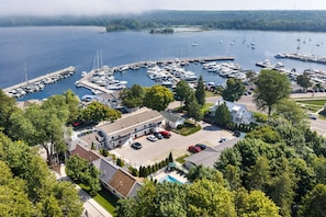 A marina with multiple boats docked, surrounded by lush greenery and residential buildings.