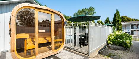 Eine Holzhütte mit Glastüren, einem weißen Zaun und einem Schild für 'Spruce & Shore Motel'.