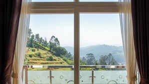 A balcony with a view of green hills and trees. - Paradise Point Ooty (Coonoor)