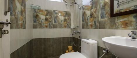 Un bagno con WC, lavabo e doccia. Le pareti presentano piastrelle con motivi astratti.