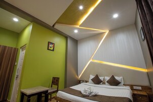 A modern hotel room with a bed, bedside table, and a chair.