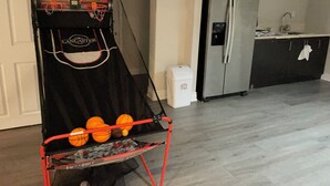 Un panier de basket avec une pancarte indiquant « VISITEUR DE LANCASHER », un réfrigérateur en acier inoxydable et un plan de travail de cuisine avec un évier.