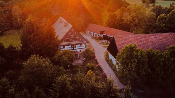 A rural house with a sloped roof, surrounded by dense trees and a clear sky. - The Oak Lodge (Lwowek Slaski)
